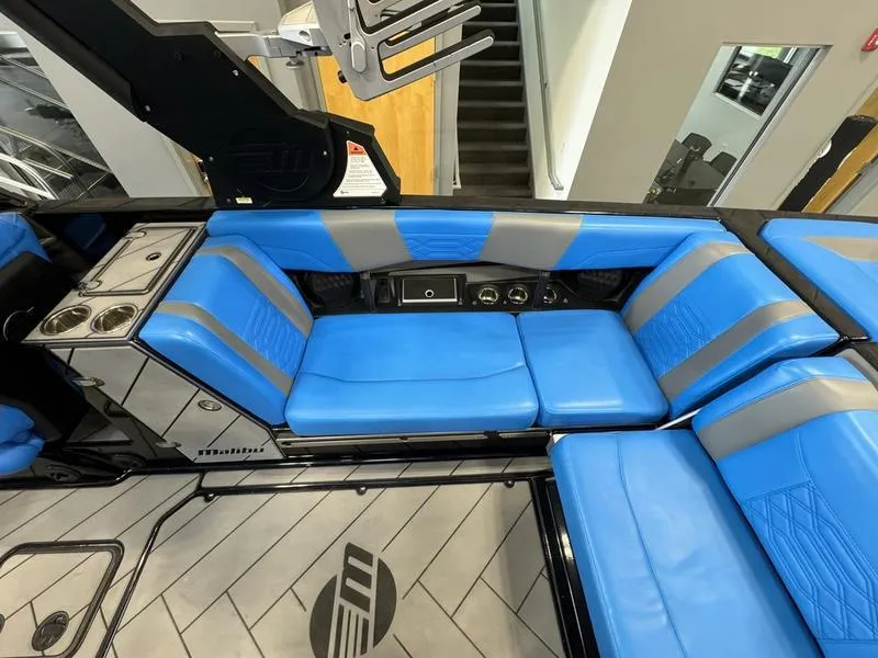 Slide: The Image of 2022 Malibu 25 LSV boat interior with blue and gray seating. - 15