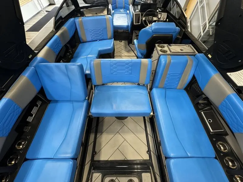 Slide: The Image of 2022 Malibu 25 LSV boat interior with blue and gray seating, modern design. - 17