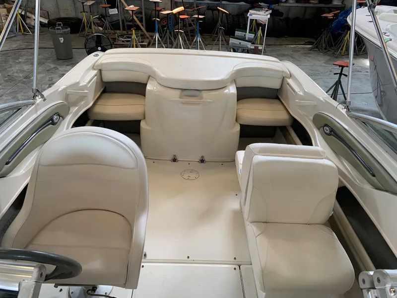 Slide: The Image of 2004 Sea Ray 200 Sport boat interior with white seating and steering wheel. - 12