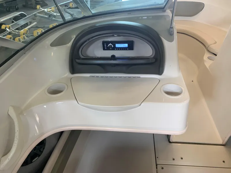 Slide: The Image of 2004 Sea Ray 200 Sport boat dashboard with cup holders and stereo system. - 14