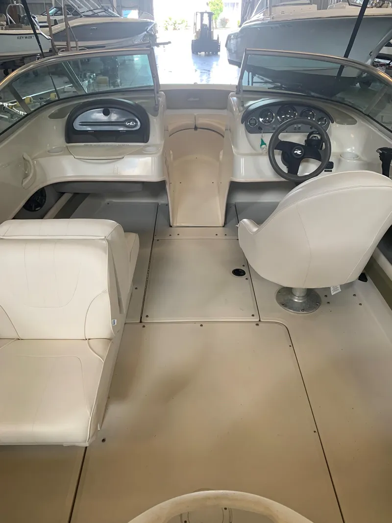 Slide: The Image of 2004 Sea Ray 200 Sport boat interior with steering wheel and seating. - 18
