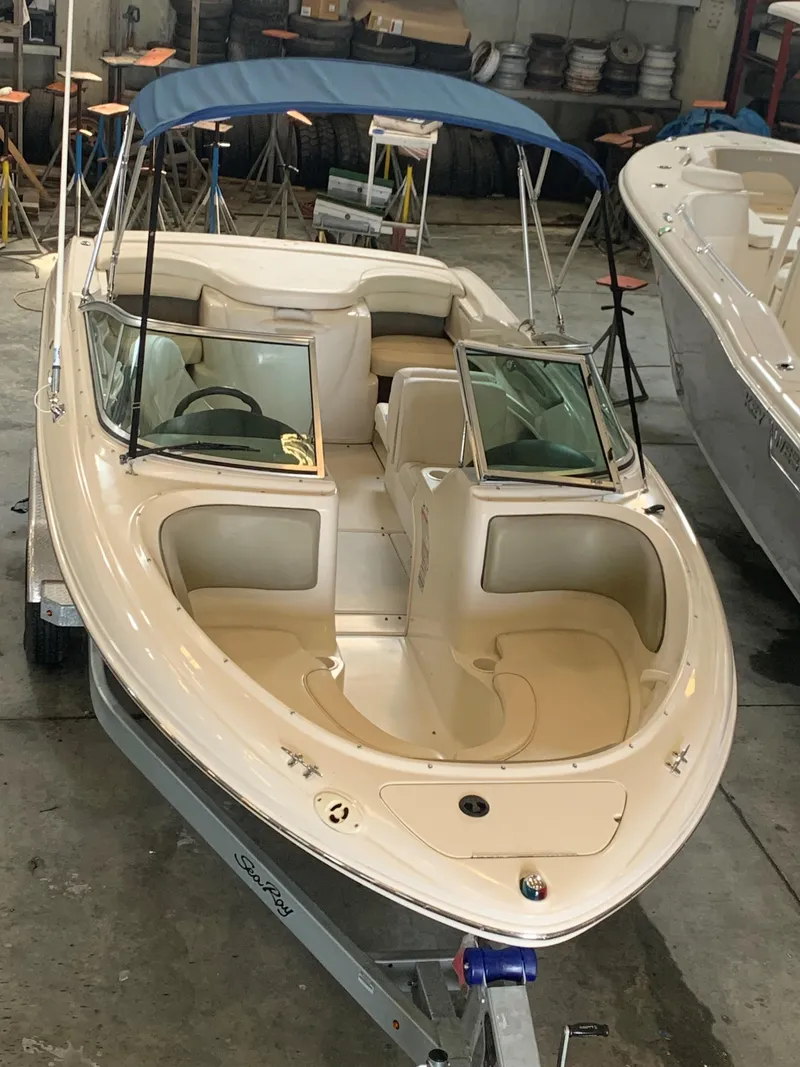 Slide: The Image of 2004 Sea Ray 200 Sport boat with blue canopy in a garage setting. - 4