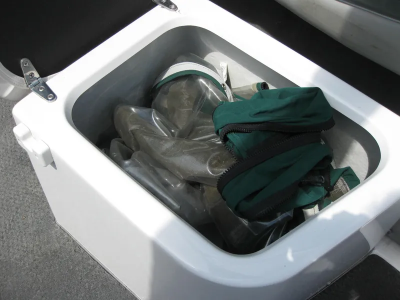 Slide: The Image of Storage compartment on 2000 Four Winns 235 Sundowner I/O boat with green gear inside. - 11