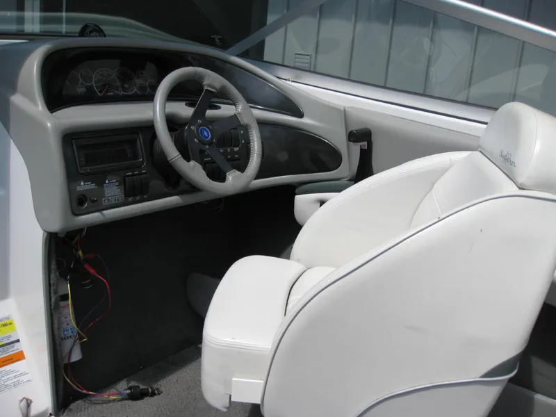 Slide: The Image of Interior of 2000 Four Winns 235 Sundowner I/O boat with steering wheel and white captain's seat. - 3