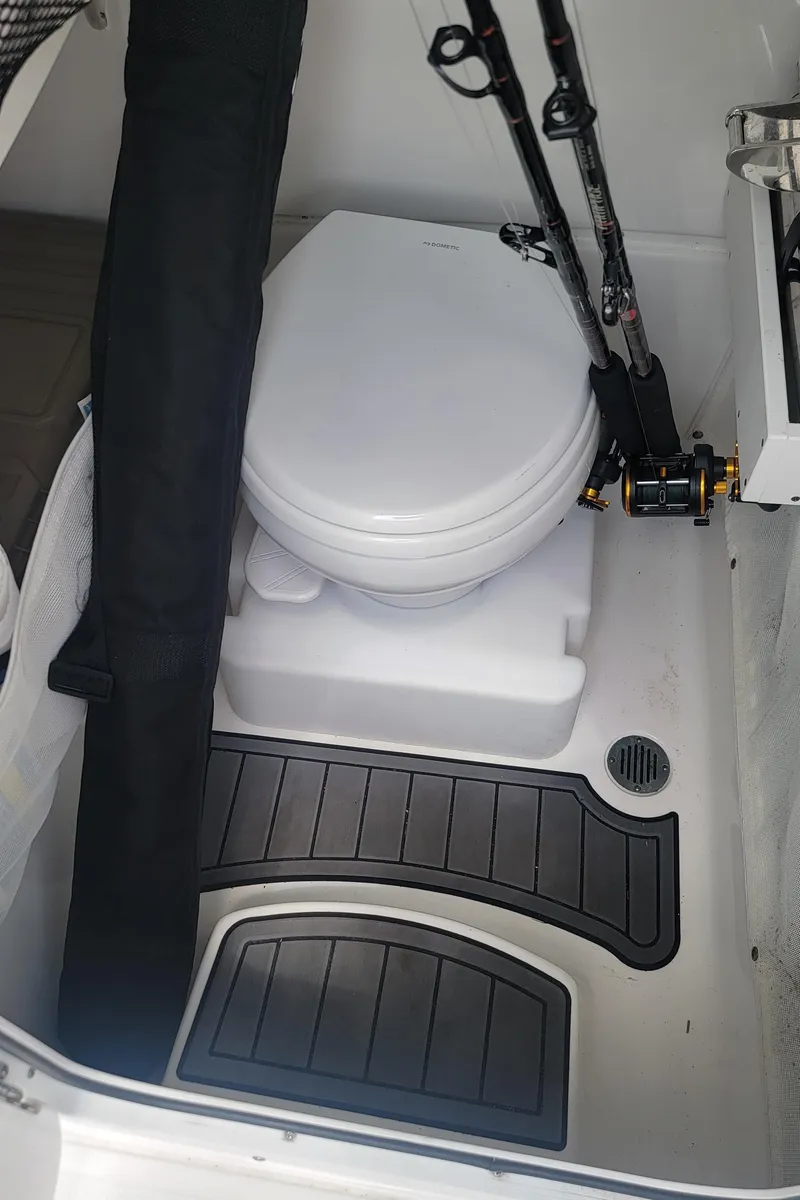 Slide: The Image of 2020 Sea Hunt Gamefish 27 boat interior with toilet and fishing rods. - 17