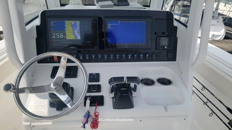 Slide: The Image of 2020 Sea Hunt Gamefish 27 dashboard with steering wheel and navigation screens. - 8