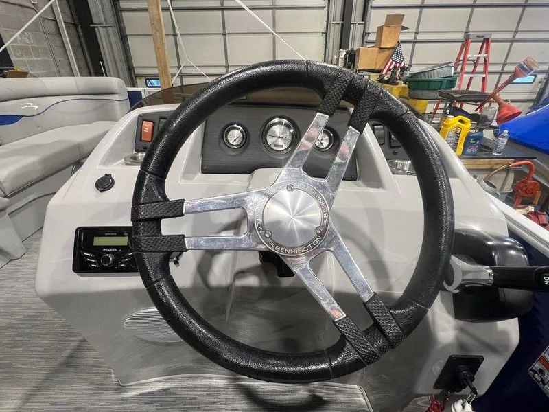 Slide: The Image of Steering wheel of a 2023 Bennington 22 SSR boat in a garage setting. - 13