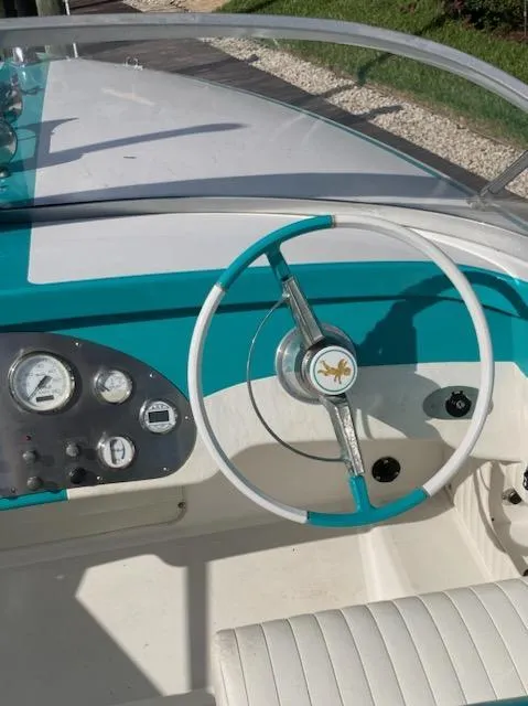 Slide: The Image of Steering wheel and dashboard of 2013 Cherubini 20 VS boat, featuring teal accents. - 11