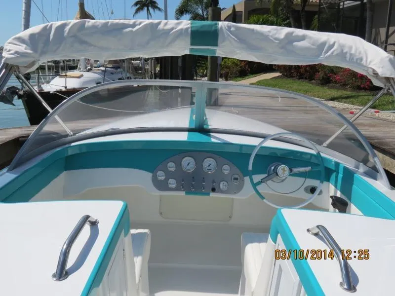 Slide: The Image of Cockpit of 2013 Cherubini 20 VS boat with teal accents and steering wheel. - 2