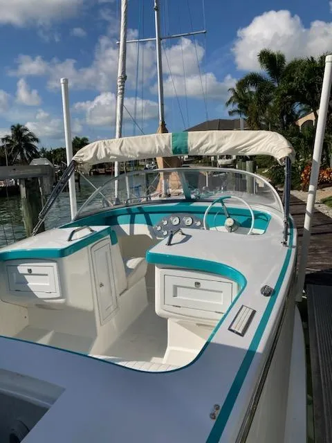 Slide: The Image of 2013 Cherubini 20 VS boat docked under sunny skies, featuring teal and white interior. - 7