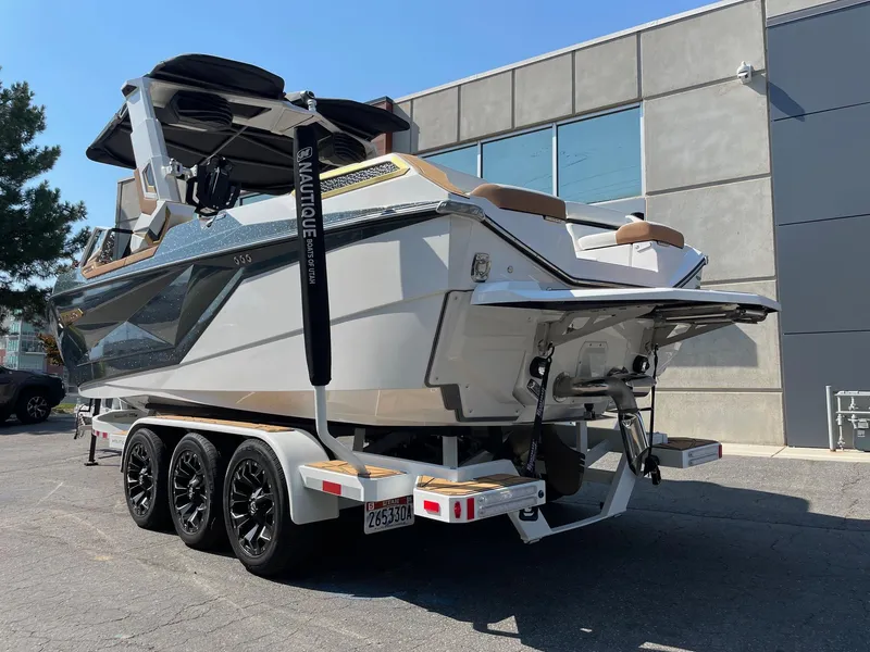 Slide: The Image of 2024 Nautique Super Air Nautique G25 Paragon boat on a trailer, parked outdoors. - 3