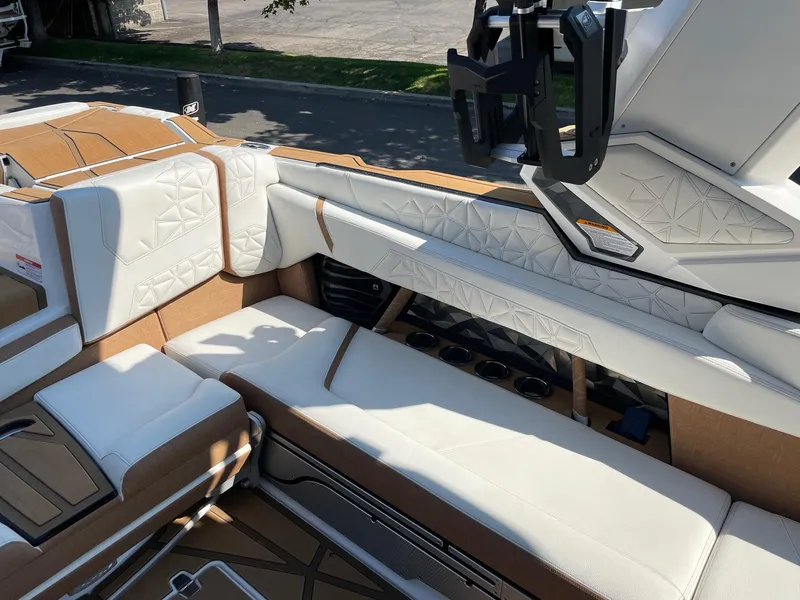 Slide: The Image of 2024 Nautique Super Air Nautique G25 Paragon interior with luxurious white and tan seating. - 7