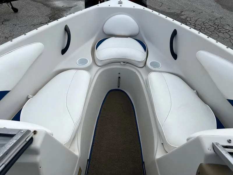 Slide: The Image of 2002 Crownline 180 BR boat interior with white cushioned seating and cup holders. - 10