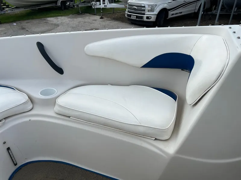 Slide: The Image of 2002 Crownline 180 BR boat interior with white and blue cushioned seating. - 11