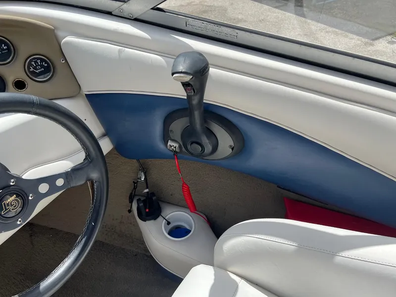Slide: The Image of Interior of a 2002 Crownline 180 BR boat showing steering wheel and throttle controls. - 13
