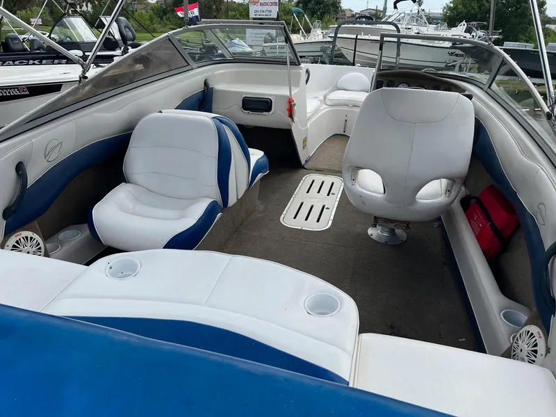 Slide: The Image of 2002 Crownline 180 BR boat interior with white and blue seating, open deck layout. - 4