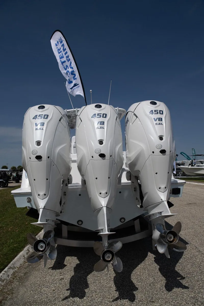 Slide: The Image of 2024 Contender 39 ST boat with triple 450 V8 engines displayed outdoors. - 1