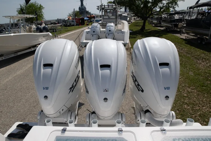 Slide: The Image of 2024 Contender 39 ST boat with triple V8 engines, parked outdoors. - 18