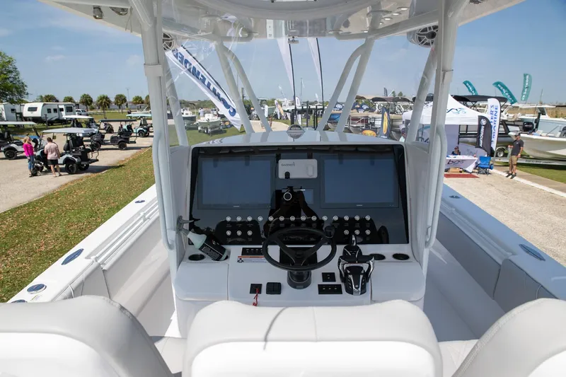 Slide: The Image of 2024 Contender 39 ST boat cockpit with modern controls and displays at a boat show. - 2