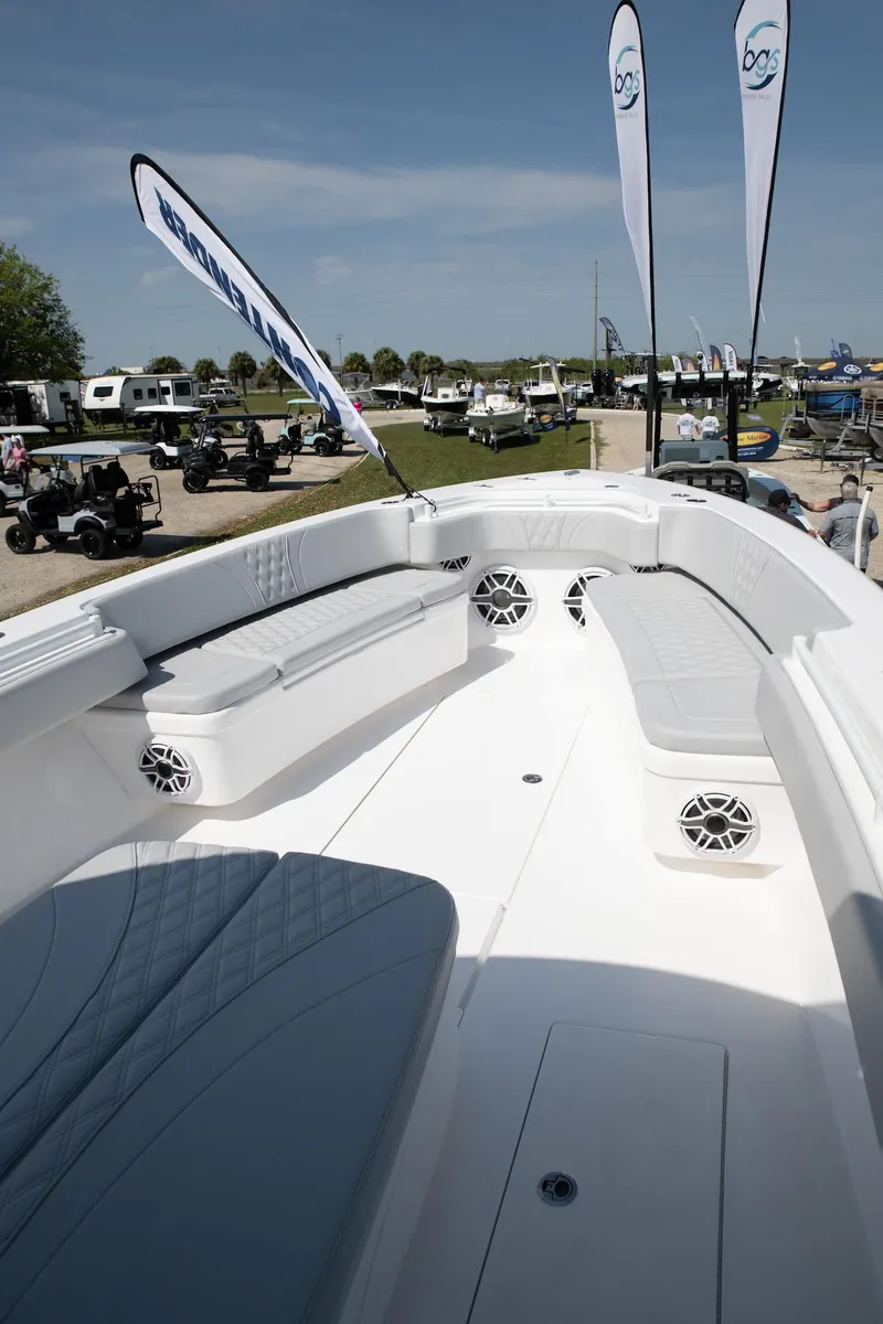 Slide: The Image of 2024 Contender 39 ST boat interior with seating and speakers at outdoor event. - 5
