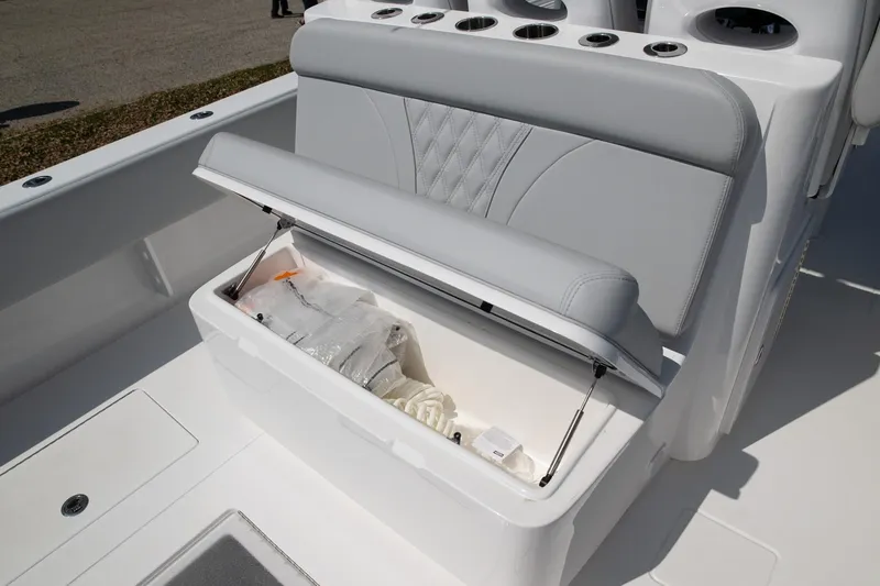 Slide: The Image of 2024 Contender 39 ST boat with open storage compartment and cushioned seating. - 9