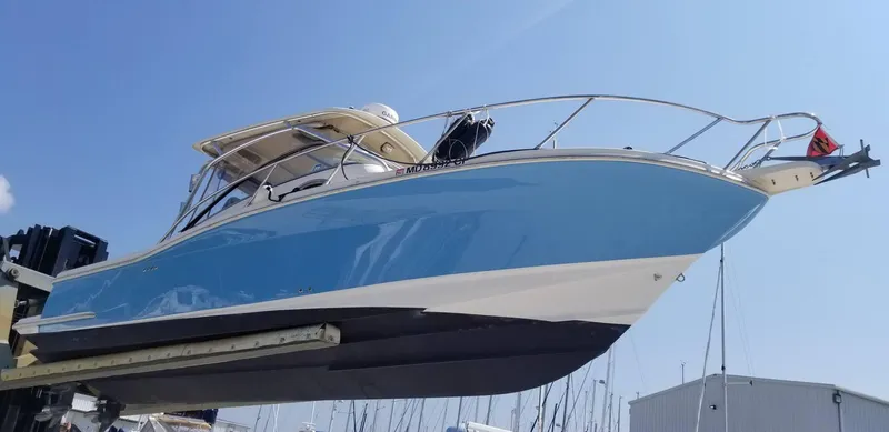 Slide: The Image of 2010 Scout 262 Abaco boat with blue hull on a lift under clear sky. - 1