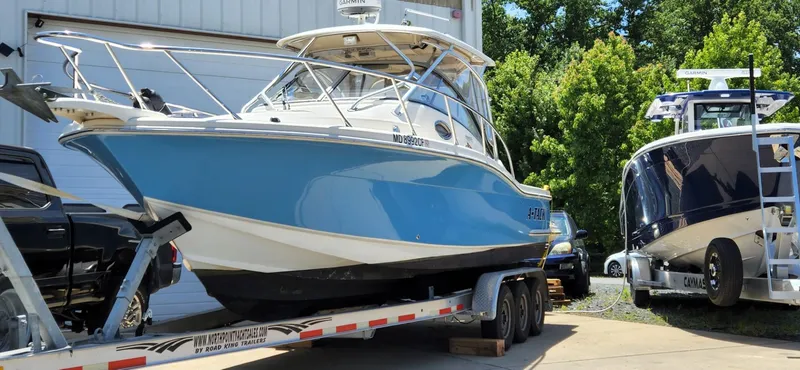 Slide: The Image of 2010 Scout 262 Abaco boat on trailer, parked outdoors near another boat. - 2