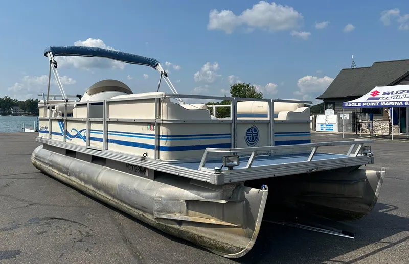 Slide: The Image of 1998 Crest II pontoon boat parked at marina under blue sky. - 1