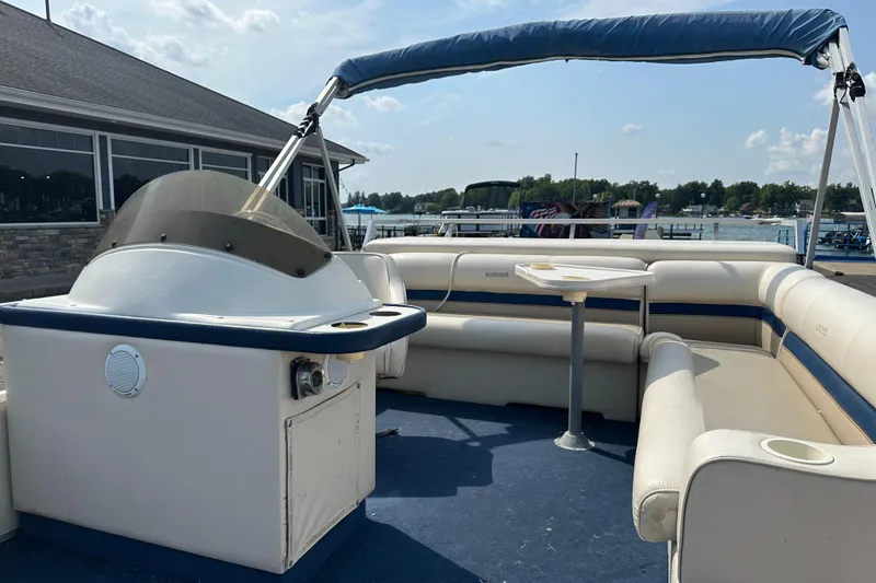 Slide: The Image of 1998 Crest II pontoon boat with seating and canopy, docked by a marina. - 10