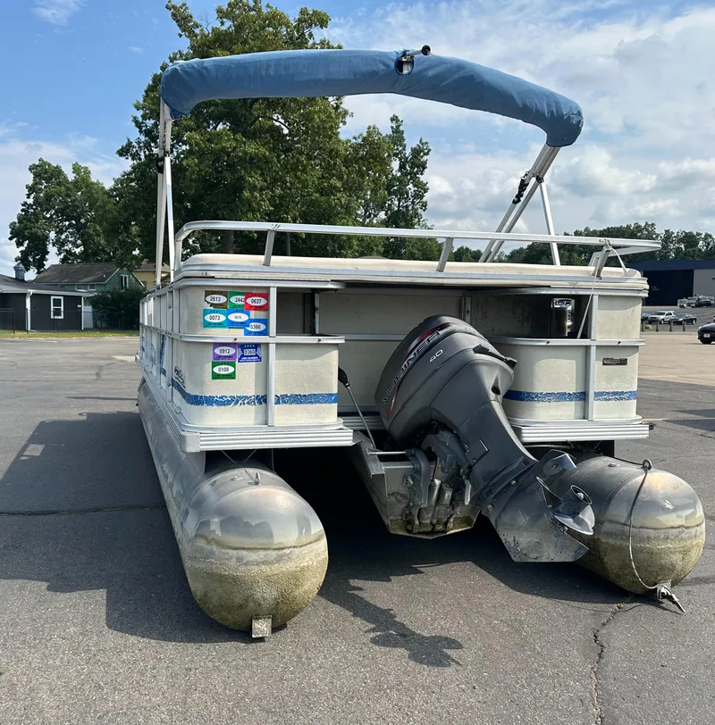 Slide: The Image of 1998 Crest II pontoon boat with outboard motor in a parking lot. - 4