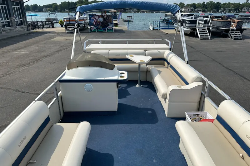 Slide: The Image of 1998 Crest II pontoon boat with spacious seating and canopy, docked by the water. - 5