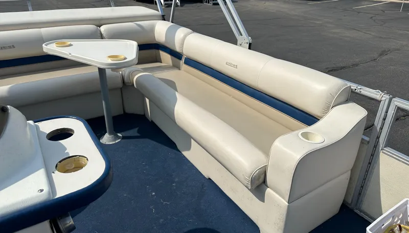 Slide: The Image of 1998 Crest II boat interior with white seating and table, featuring cup holders. - 8