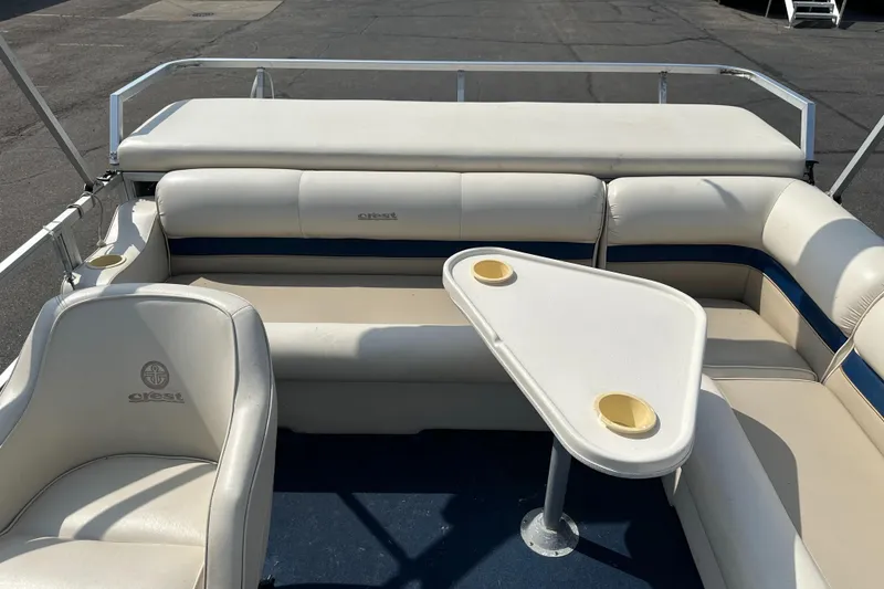 Slide: The Image of 1998 Crest II boat interior with white seating and table, featuring cup holders. - 9