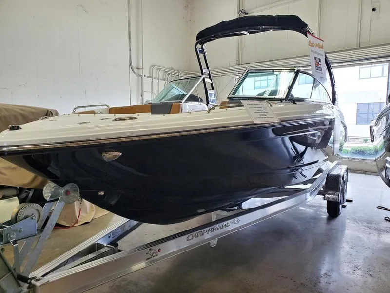 Slide: The Image of 2024 Chaparral 23 SSi OB boat in showroom, sleek design, black hull, on trailer. - 8