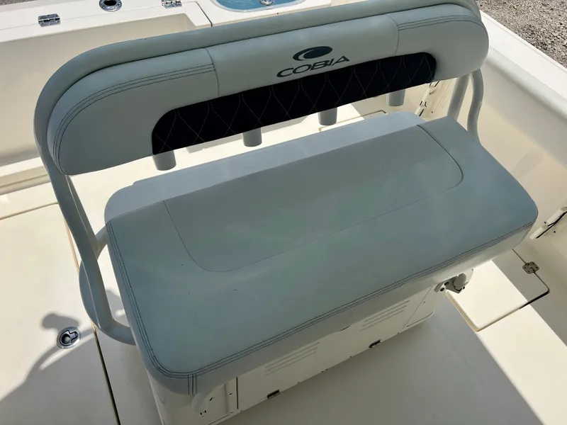 Slide: The Image of 2023 Cobia 237 CC boat seating with storage compartment. - 10