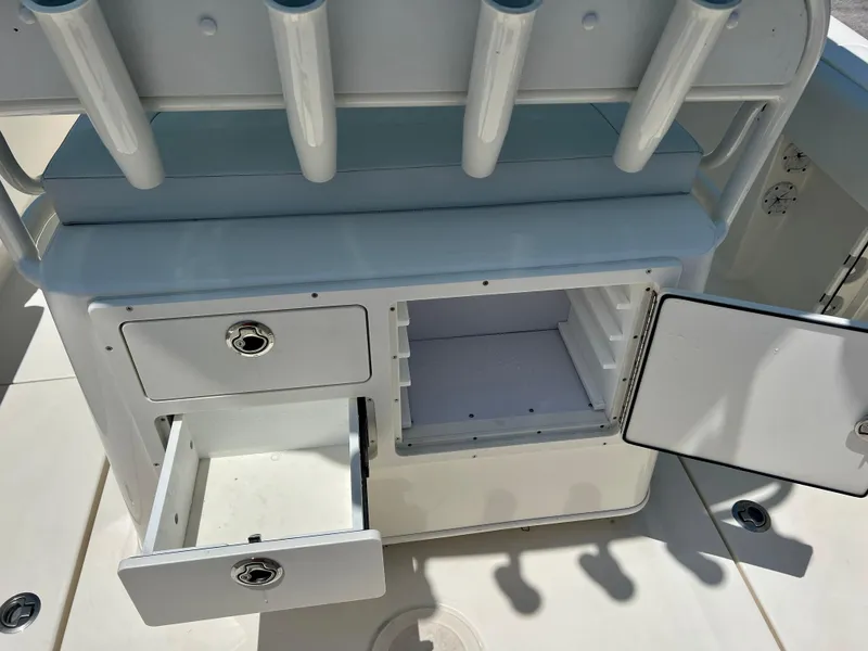 Slide: The Image of 2023 Cobia 237 CC boat storage compartments and rod holders. - 11