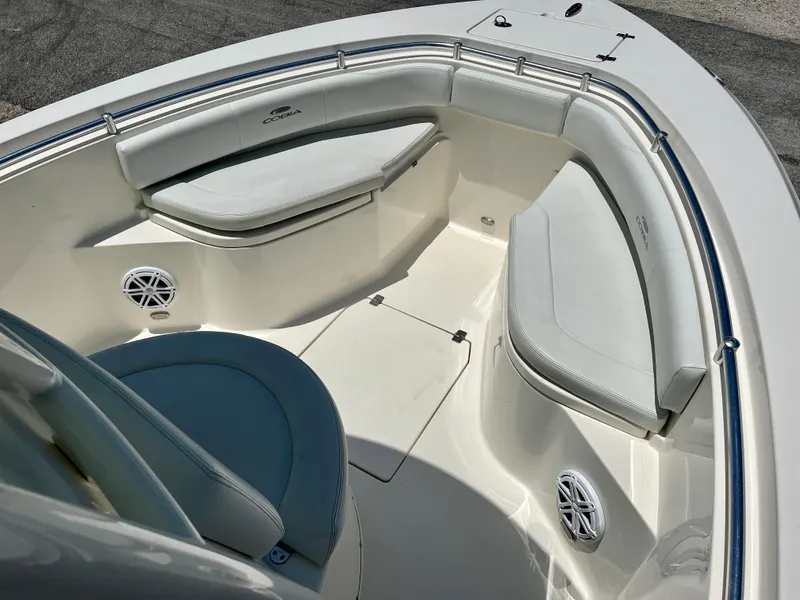 Slide: The Image of 2023 Cobia 237 CC boat interior with cushioned seating and speakers. - 13