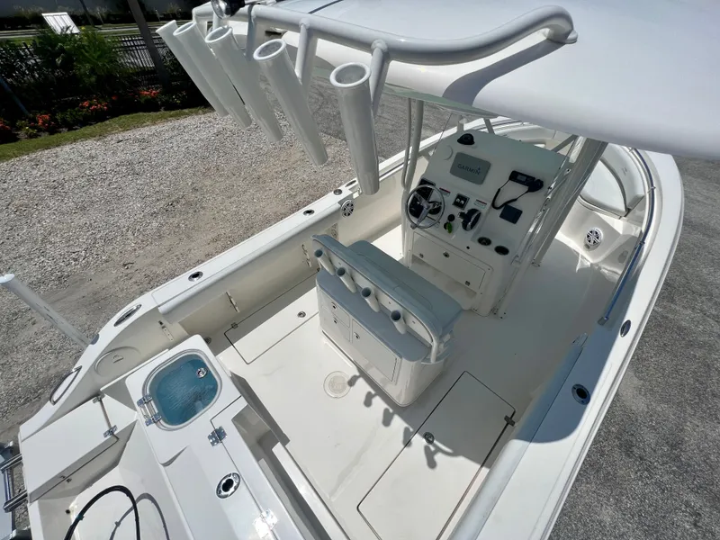 Slide: The Image of 2023 Cobia 237 CC boat interior with helm, seating, and rod holders. - 14