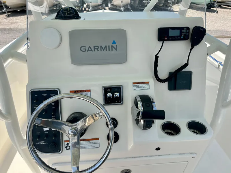 Slide: The Image of 2023 Cobia 237 CC boat dashboard with Garmin navigation system and steering wheel. - 16