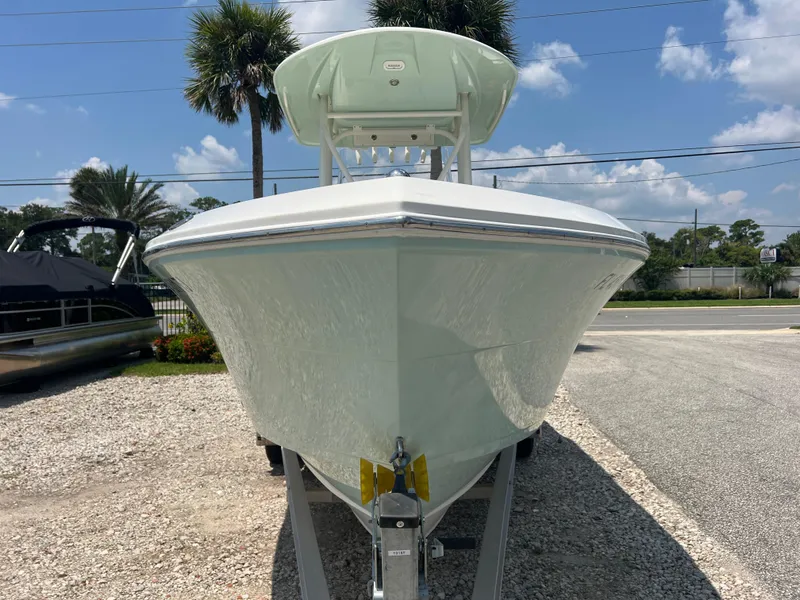 Slide: The Image of 2023 Cobia 237 CC boat on trailer, sunny day, palm trees in background. - 2