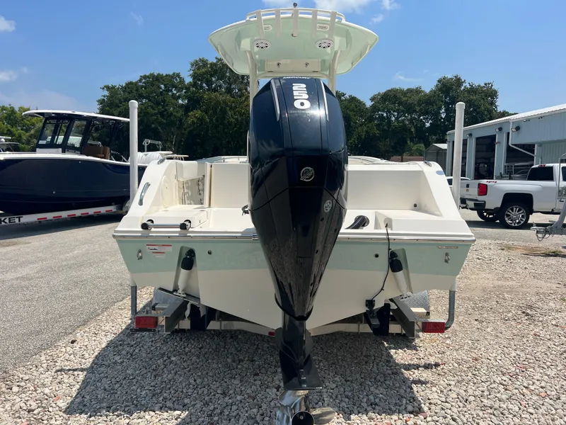 Slide: The Image of 2023 Cobia 237 CC boat with outboard motor in a marina setting. - 6
