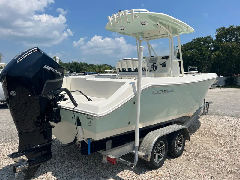Slide: The Image of 2023 Cobia 237 CC boat with Mercury engine on trailer, parked outdoors. - 7