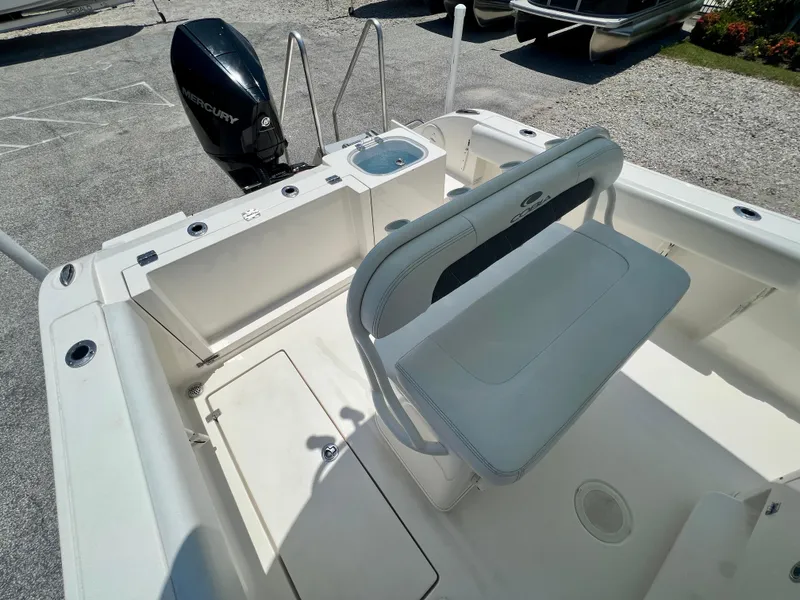 Slide: The Image of 2023 Cobia 237 CC boat interior with Mercury engine, featuring seating and storage compartments. - 8