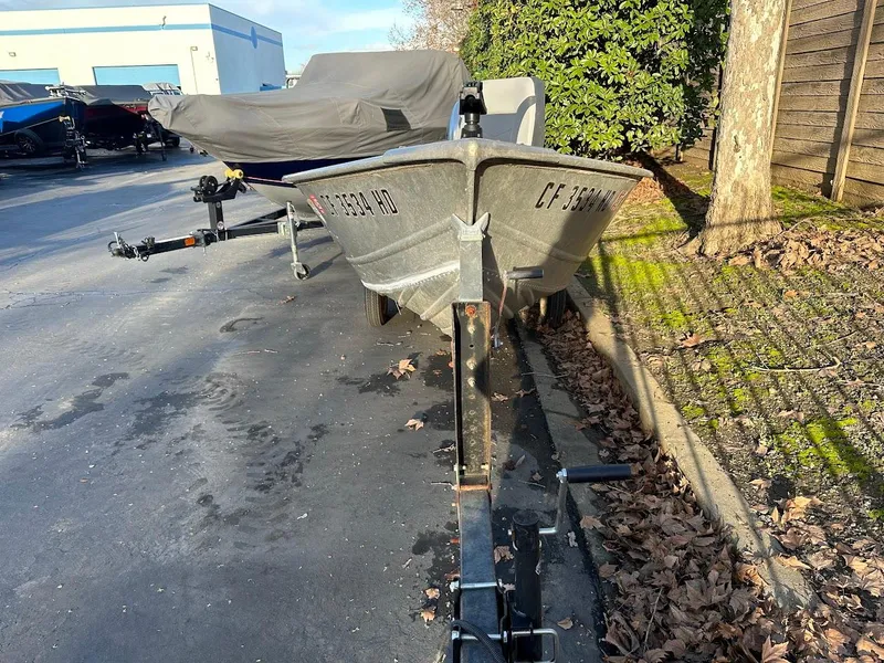 Slide: The Image of 1983 Valco 12 boat on trailer, parked outdoors, surrounded by autumn leaves. - 3
