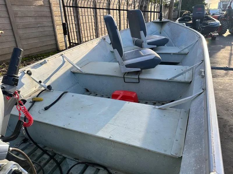 Slide: The Image of 1983 Valco 12 boat with dual seats, metal body, and outdoor setting. - 7