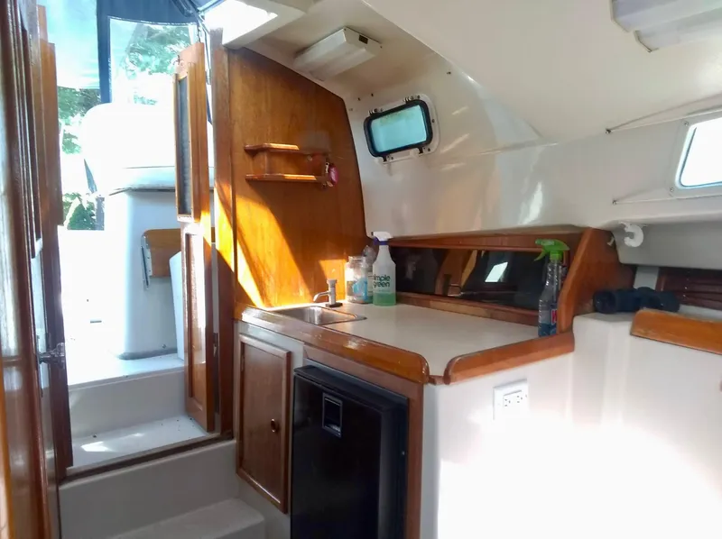 Slide: The Image of 1987 Hinterhoeller Limestone Express boat interior with kitchenette and wooden cabinetry. - 13