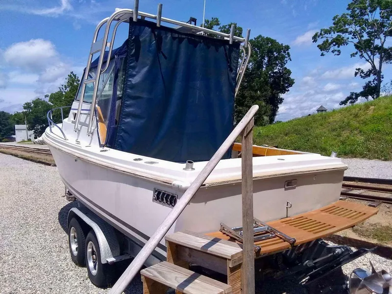 Slide: The Image of 1987 Hinterhoeller Limestone Express boat on trailer, blue canopy, outdoor setting. - 2