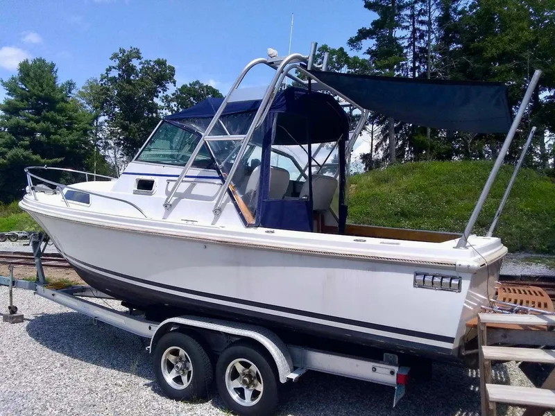 Slide: The Image of 1987 Hinterhoeller Limestone Express boat on trailer, with canopy, parked outdoors. - 3