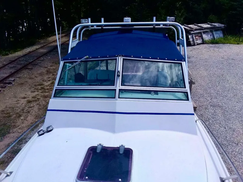 Slide: The Image of 1987 Hinterhoeller Limestone Express boat with blue canopy, docked on gravel near railway tracks. - 4