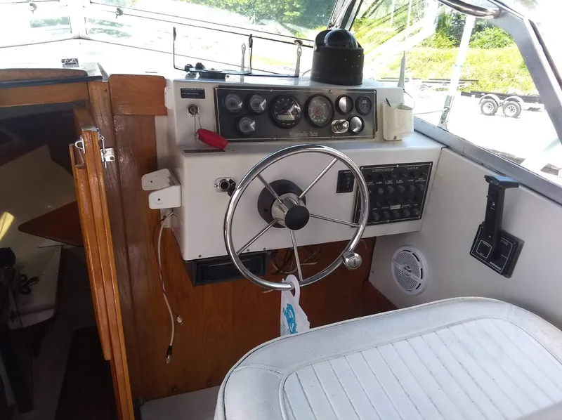 Slide: The Image of 1987 Hinterhoeller Limestone Express boat cockpit with steering wheel and control panel. - 6